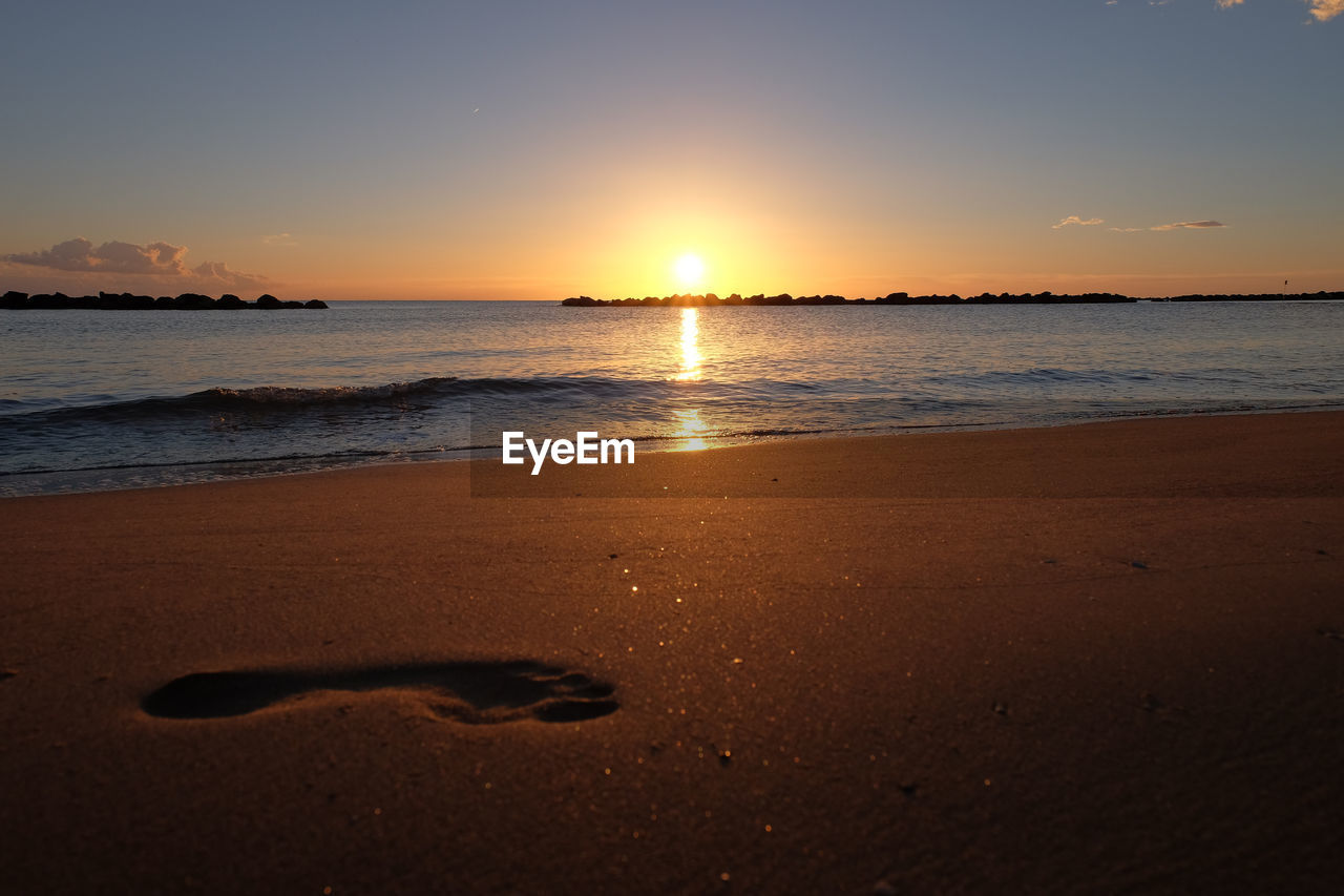 SCENIC VIEW OF SEA AGAINST SKY AT SUNSET