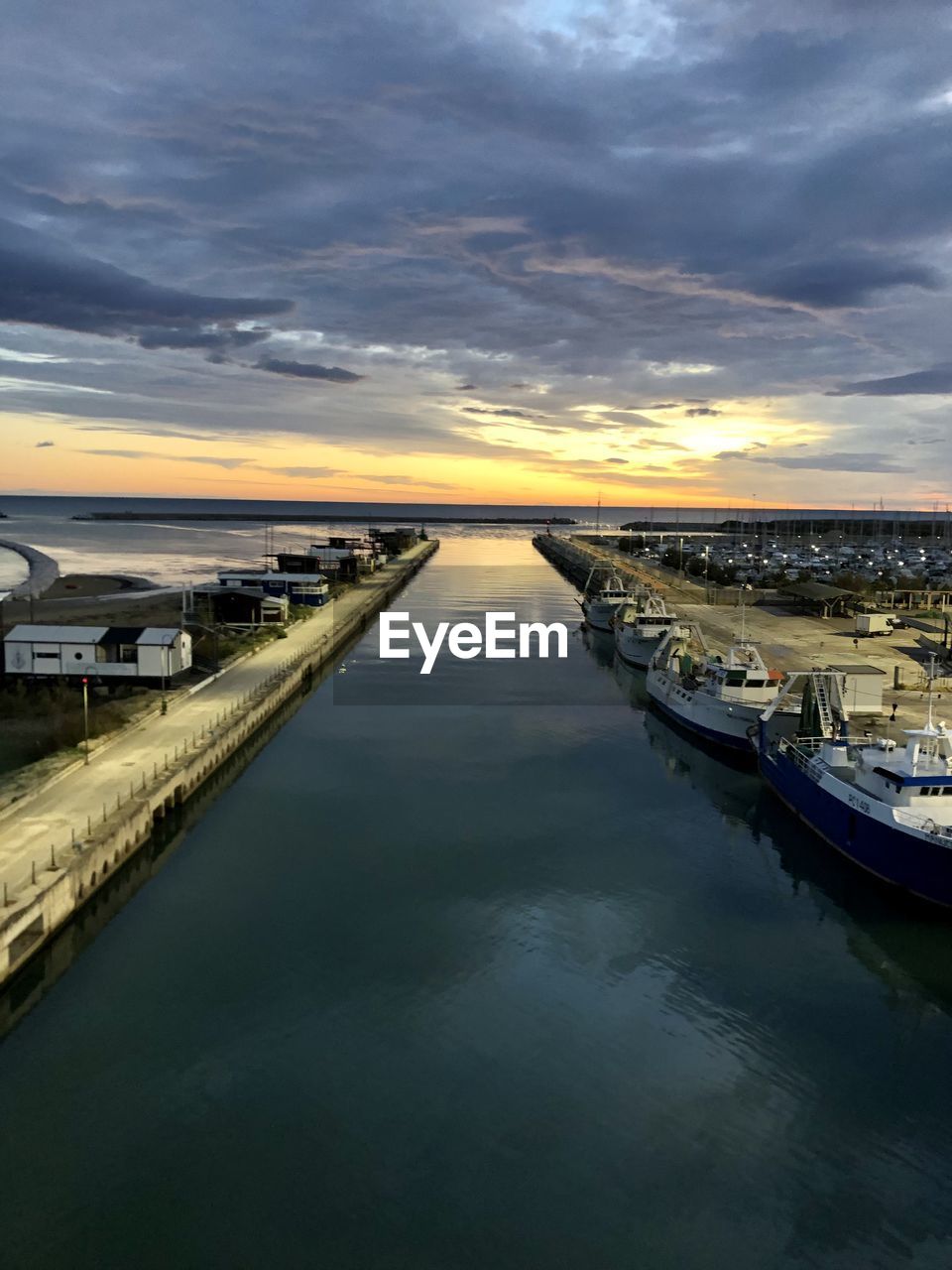 water, sky, reflection, sea, cloud, sunset, transportation, nautical vessel, coast, nature, horizon, dusk, dock, architecture, mode of transportation, evening, vehicle, scenics - nature, no people, bay, beauty in nature, travel destinations, shore, ocean, travel, channel, environment, outdoors, landscape, boat, land, tranquility, harbor, pier, built structure, city, dramatic sky, waterway, wave, beach, twilight, tranquil scene, moored, tourism, sunlight