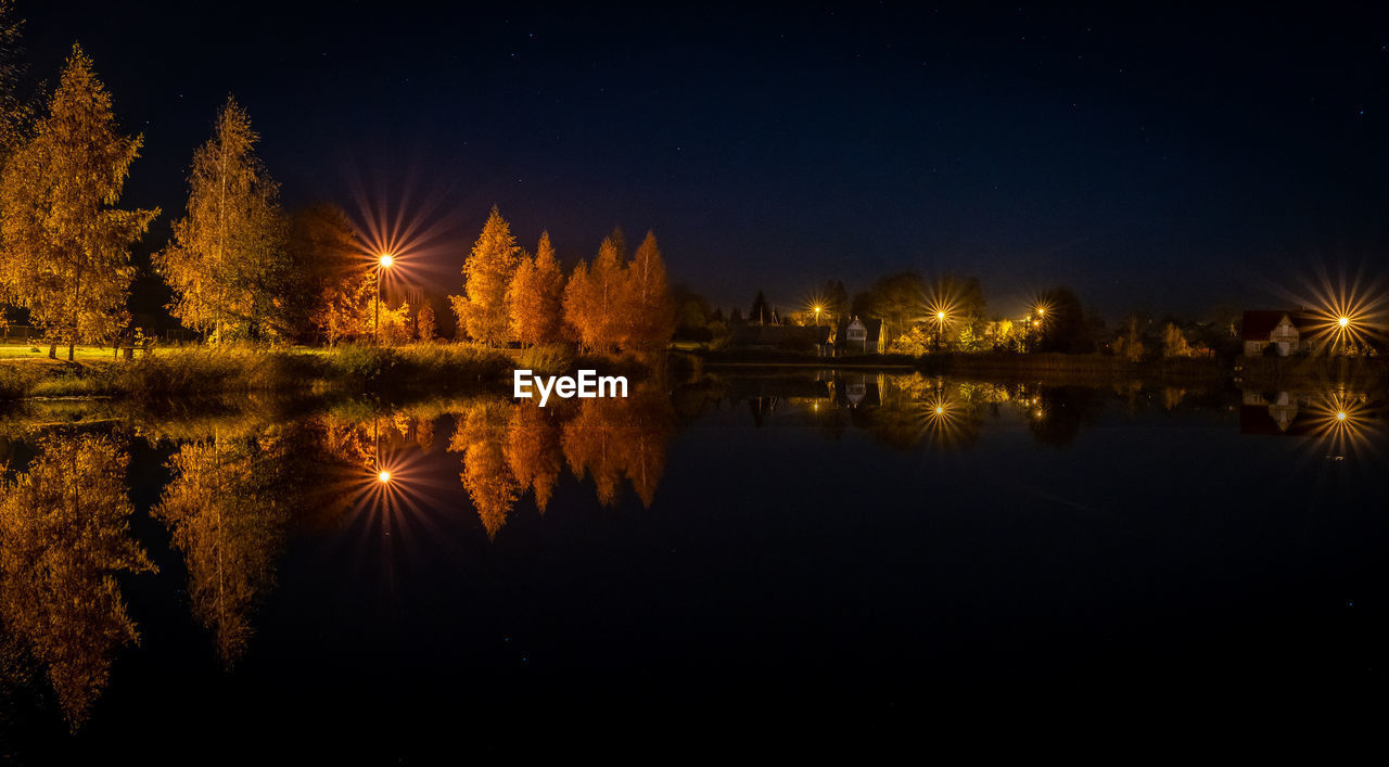 Scenic view of lake against sky at night