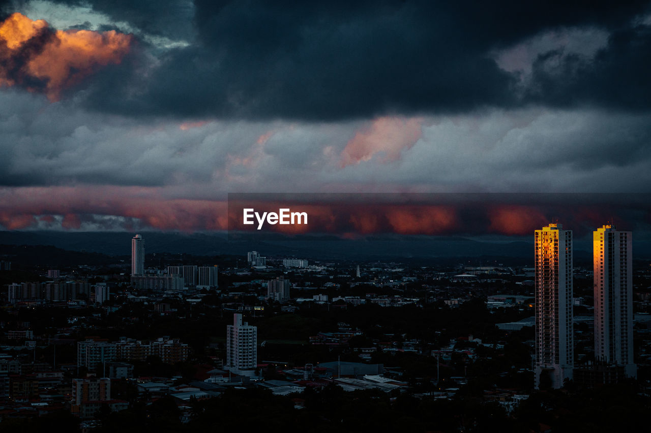 Aerial view of buildings in city at sunset