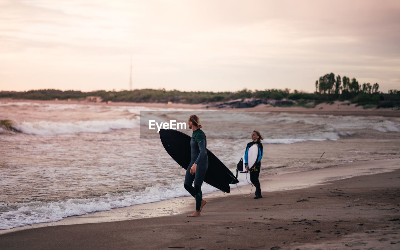 People with surfboard walking at beach