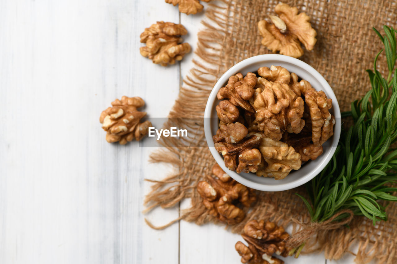 Top view of walnut in white cup on wood background. healthy nuts concept. 