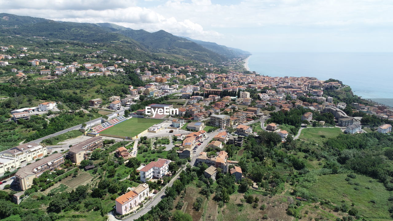 High angle view of townscape by sea against sky