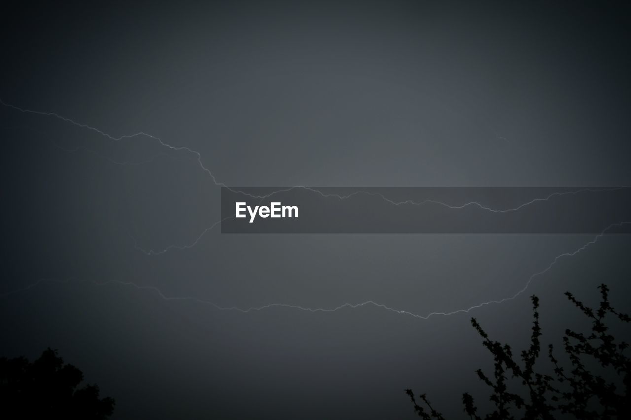 LOW ANGLE VIEW OF LIGHTNING OVER MOUNTAIN