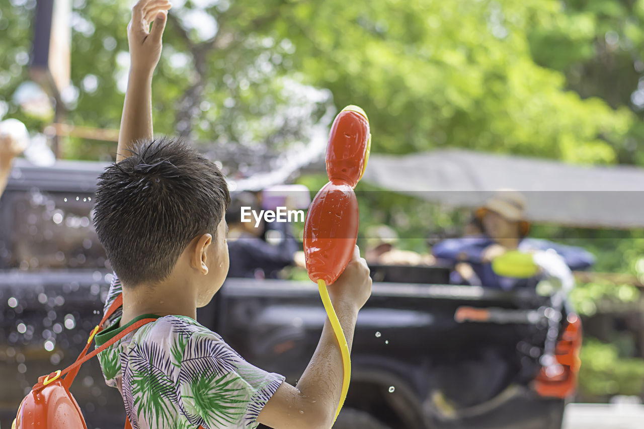 Rear view of boy holding squirt gun