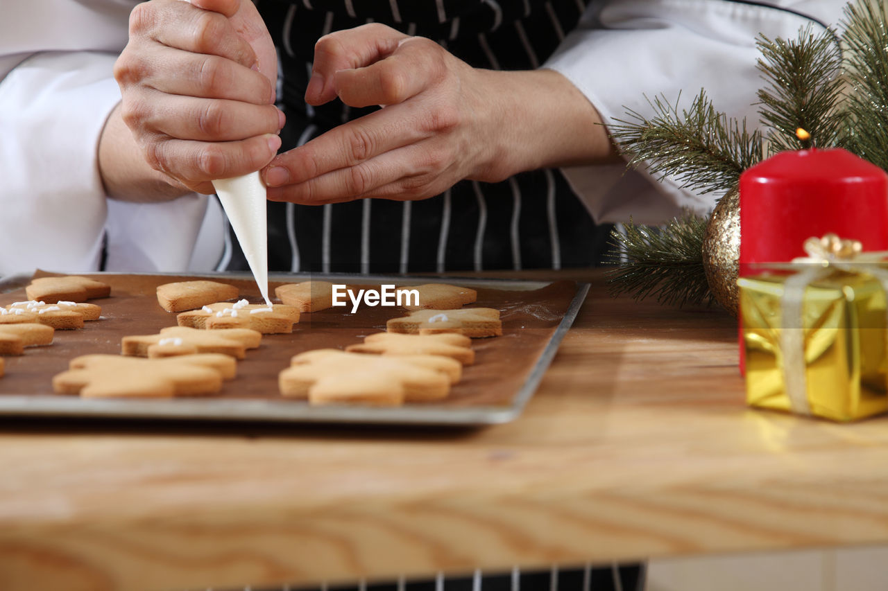 Midsection of chef preparing gingerbread cookies on table