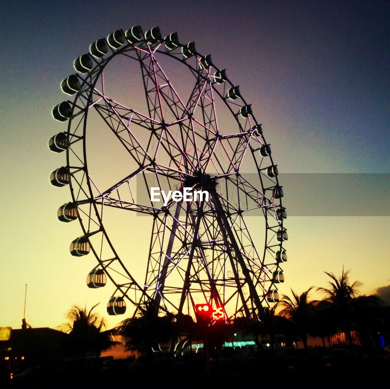 Silhouette of ferris wheel at sunset