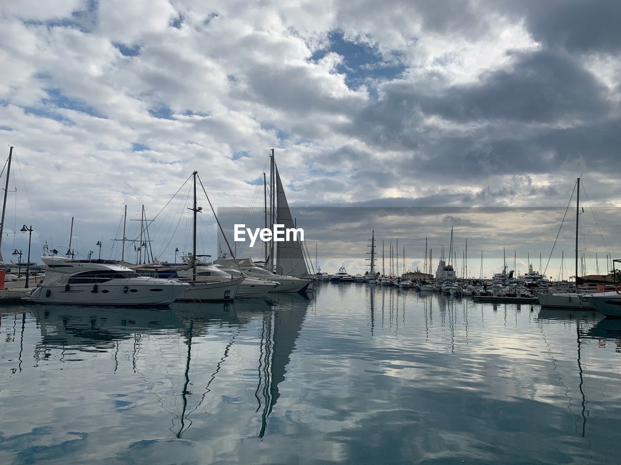 SAILBOATS MOORED IN HARBOR