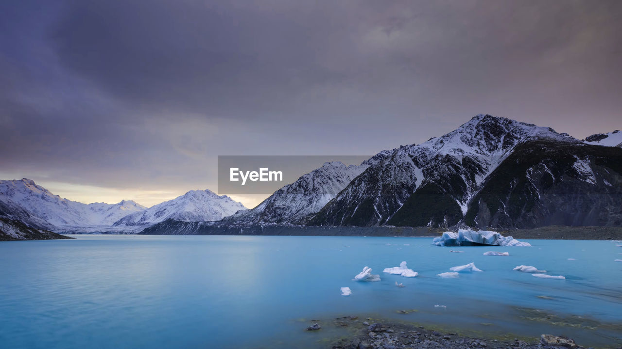 Scenic view of lake and snowcapped mountains against sky