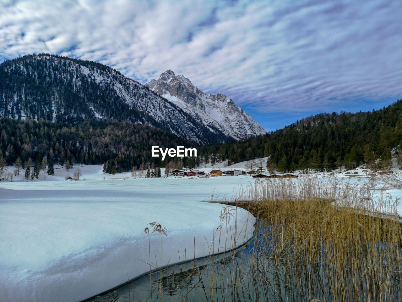 Scenic view of lake by snowcapped mountains against sky