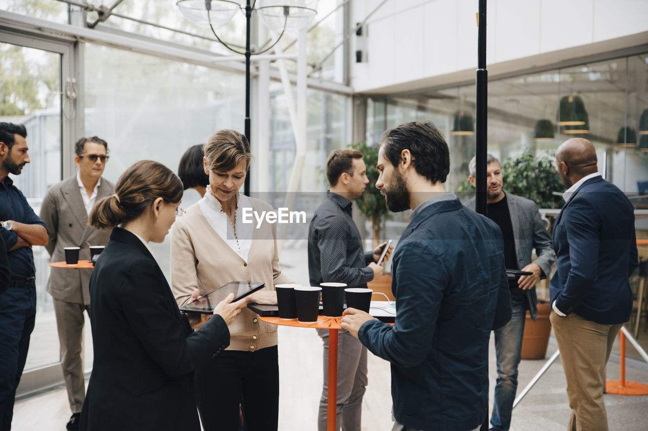 Male and female entrepreneurs talking while standing in office