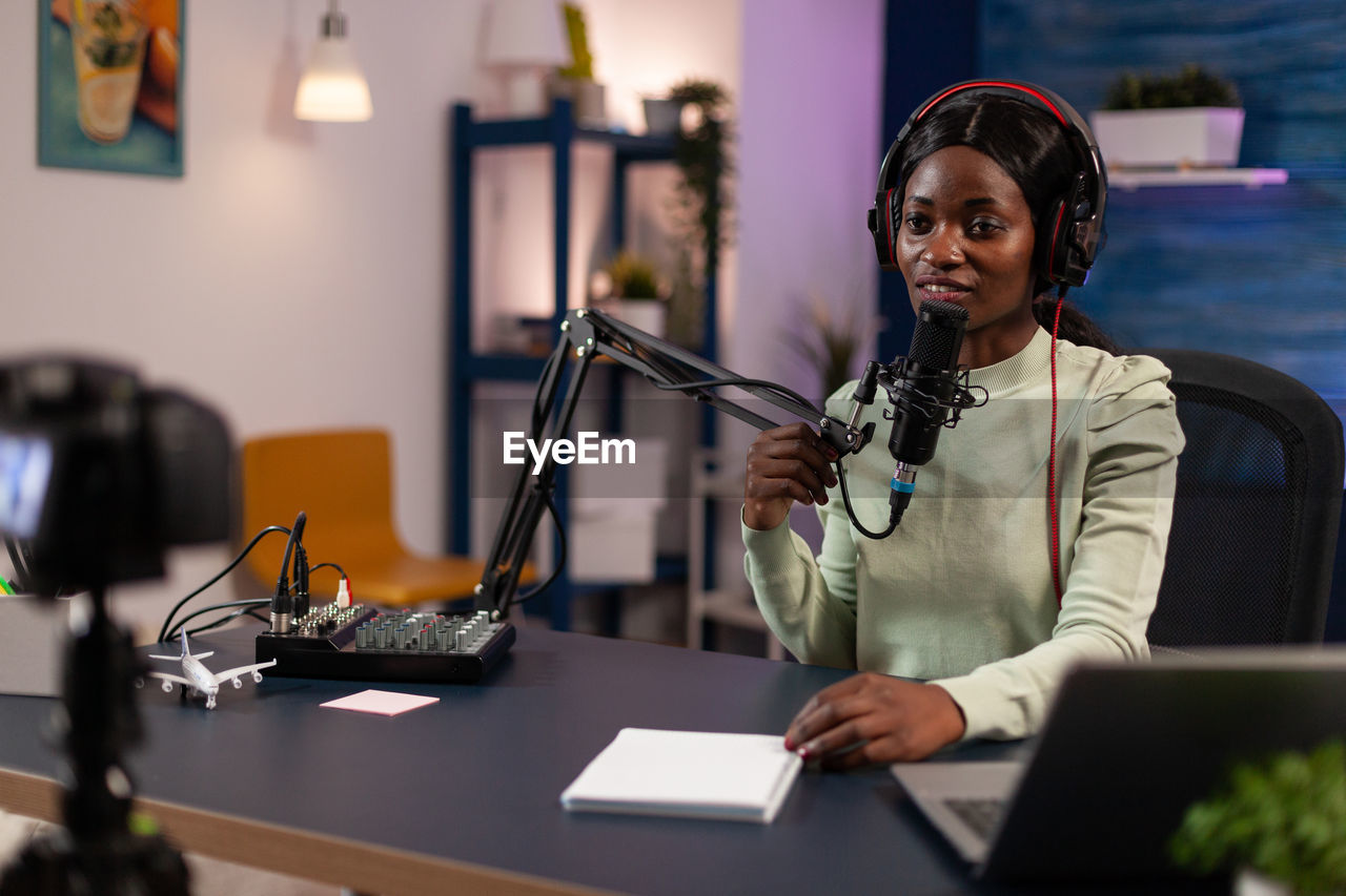 Woman podcasting on microphone at home