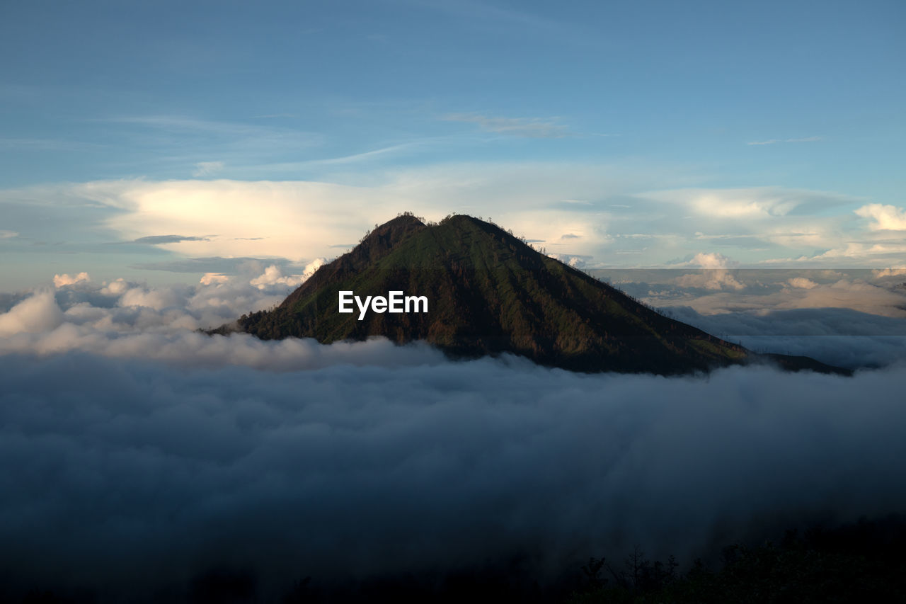 Scenic view of volcanic mountain against sky during sunset