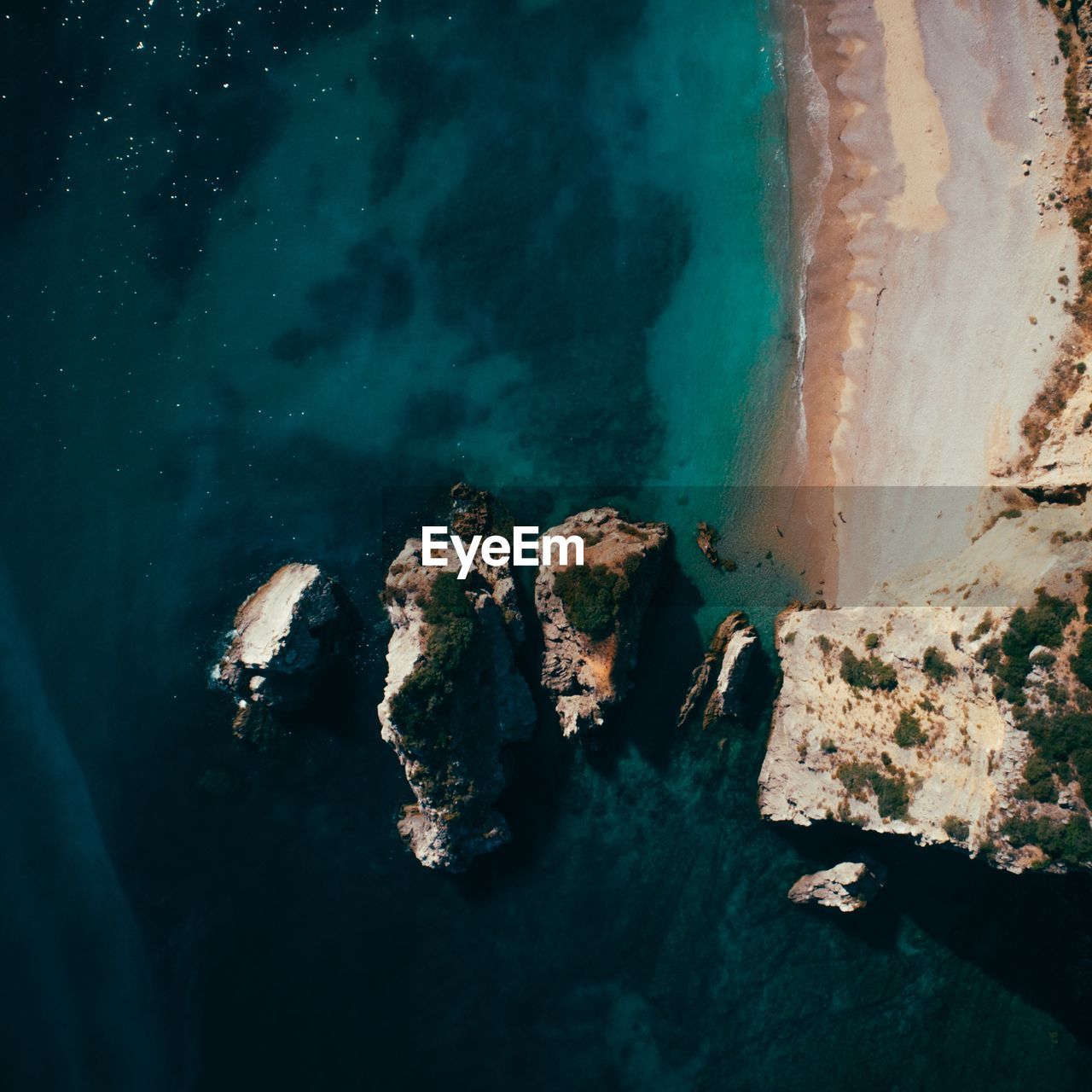 HIGH ANGLE VIEW OF ROCK FORMATIONS ON SHORE