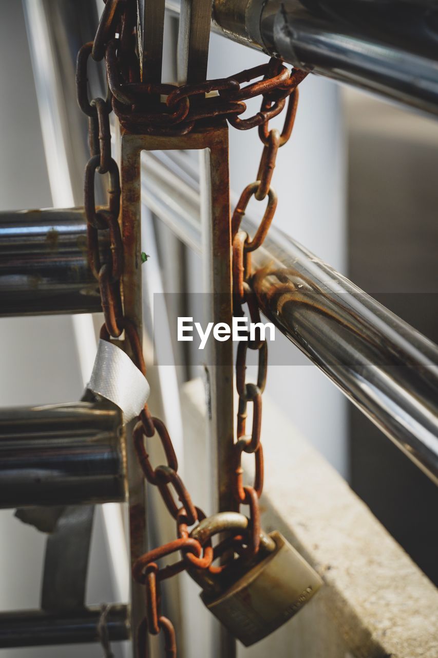 Close-up of chain and lock by railing