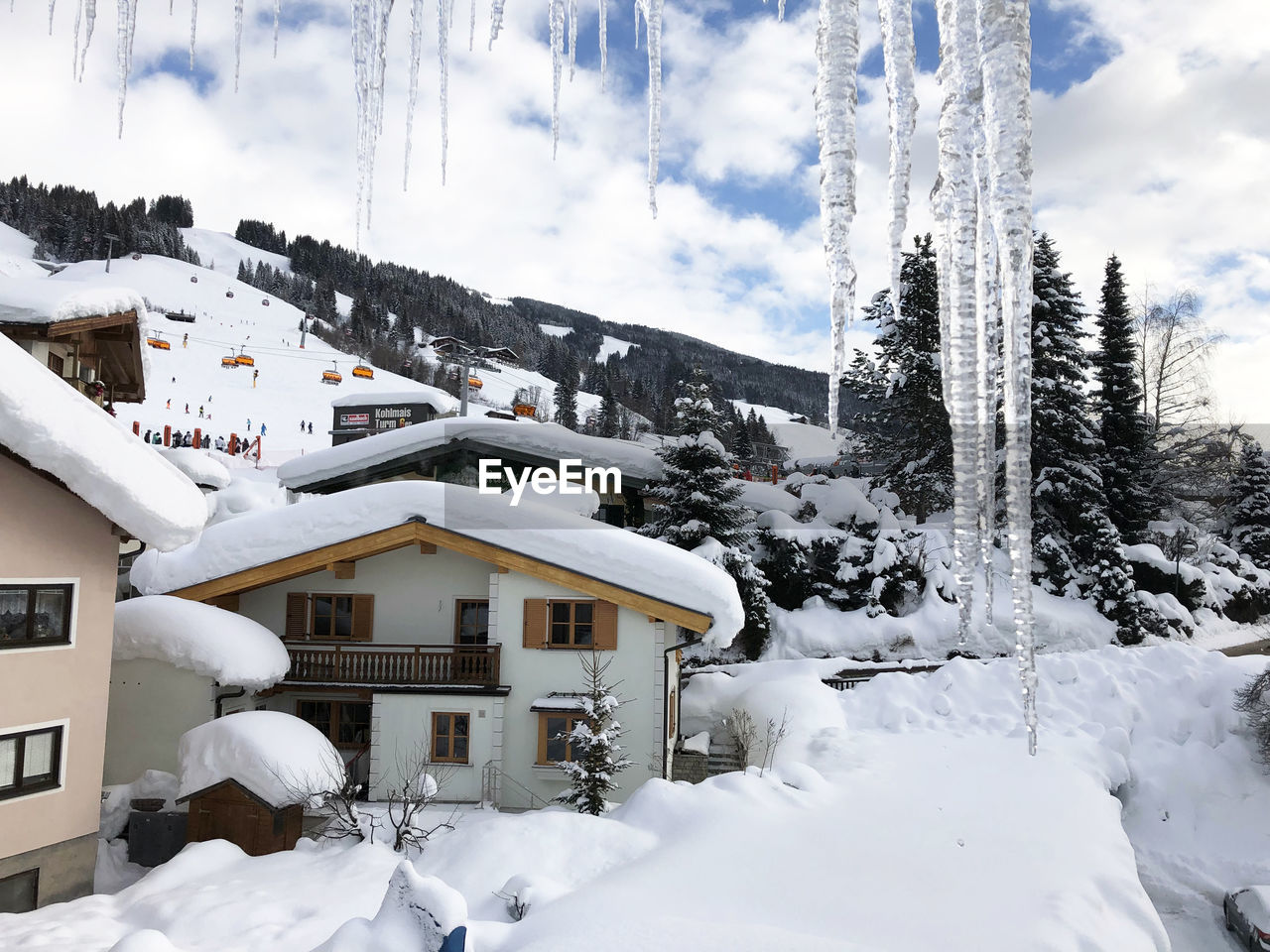 Snow covered houses and buildings against sky