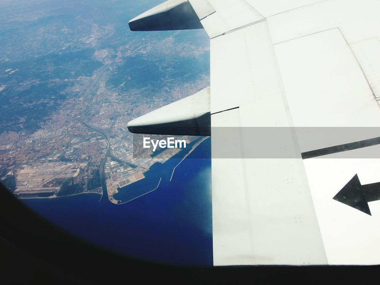 Cityscape seen through airplane window flying over sea