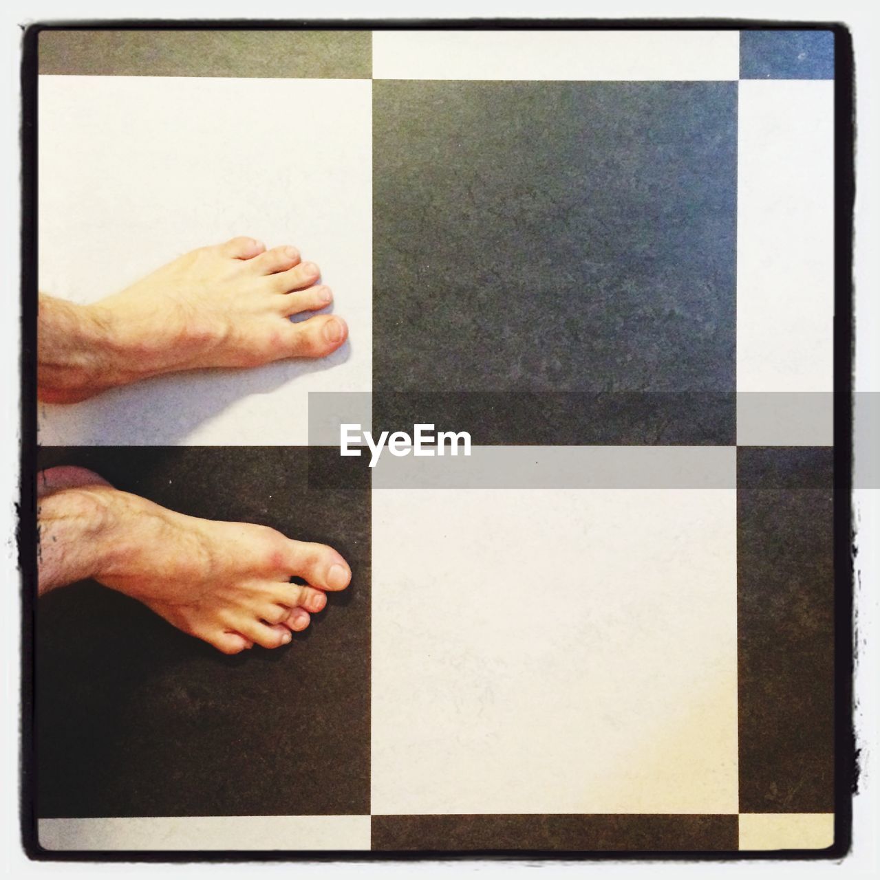 Low section of man on black and white tiled floor