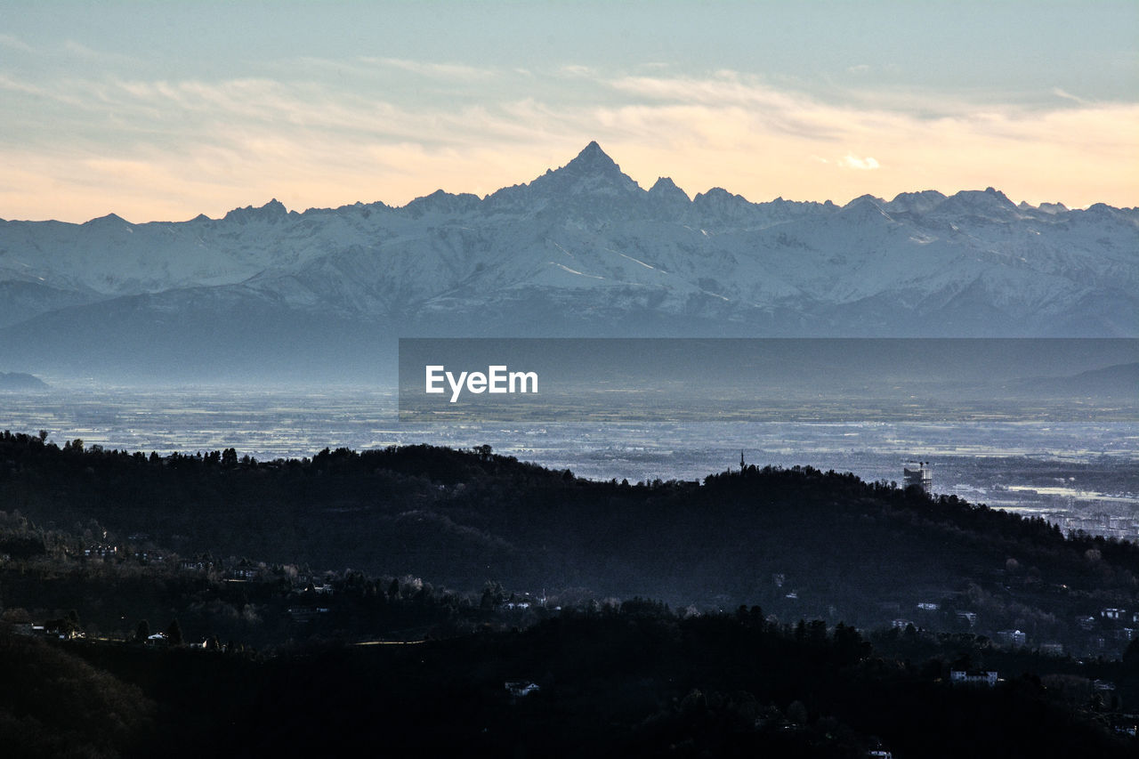 Scenic view of snowcapped mountains against sky during sunset