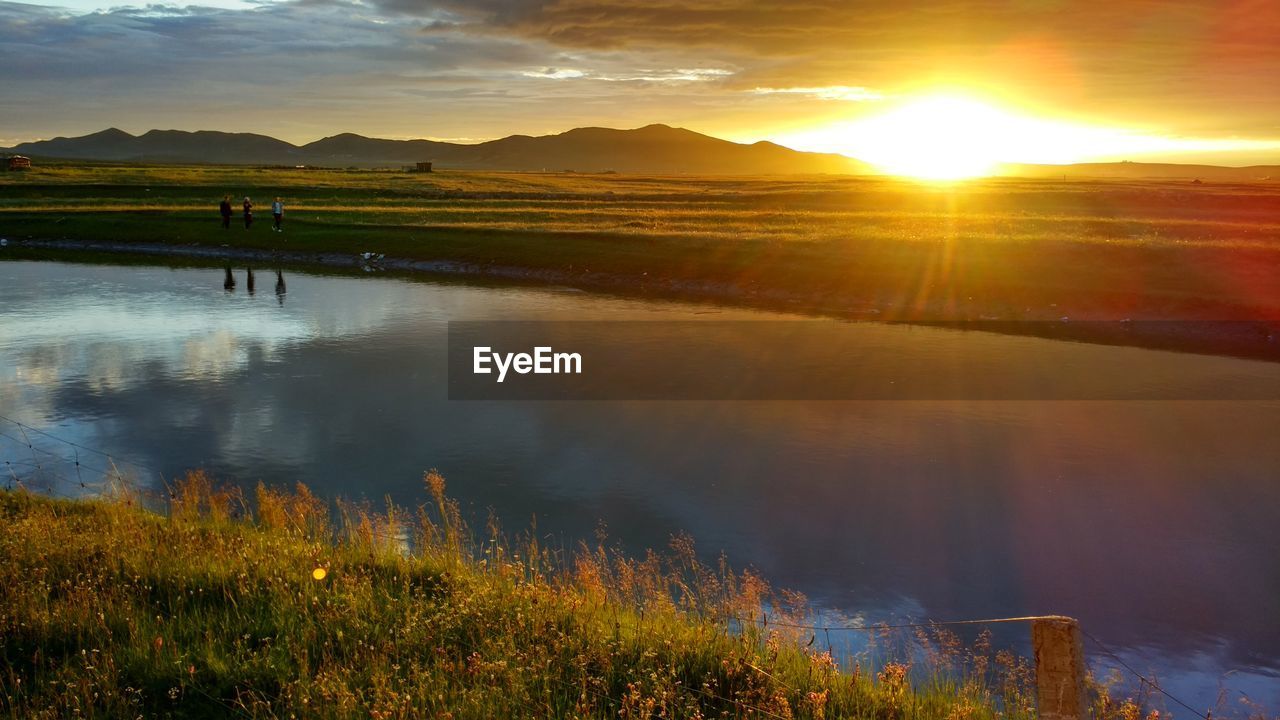 Scenic shot of calm lake at sunset