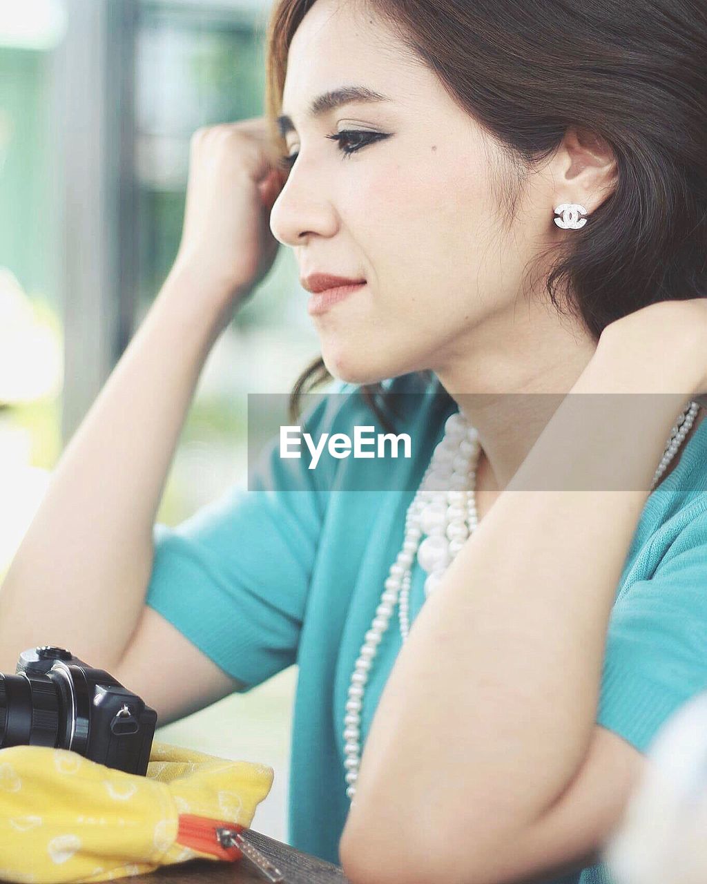 Close-up of beautiful woman sitting by table