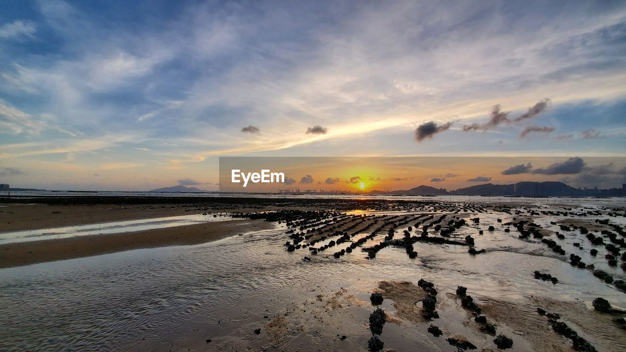 Scenic view of beach against sky during sunset