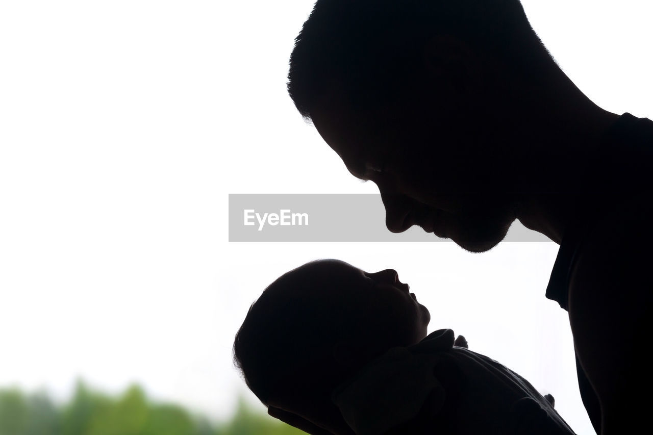 PORTRAIT OF SILHOUETTE FATHER WITH DAUGHTER AGAINST SKY