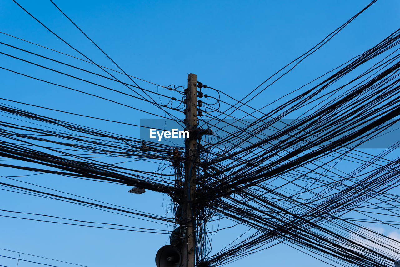 LOW ANGLE VIEW OF ELECTRICITY PYLONS AGAINST CLEAR BLUE SKY