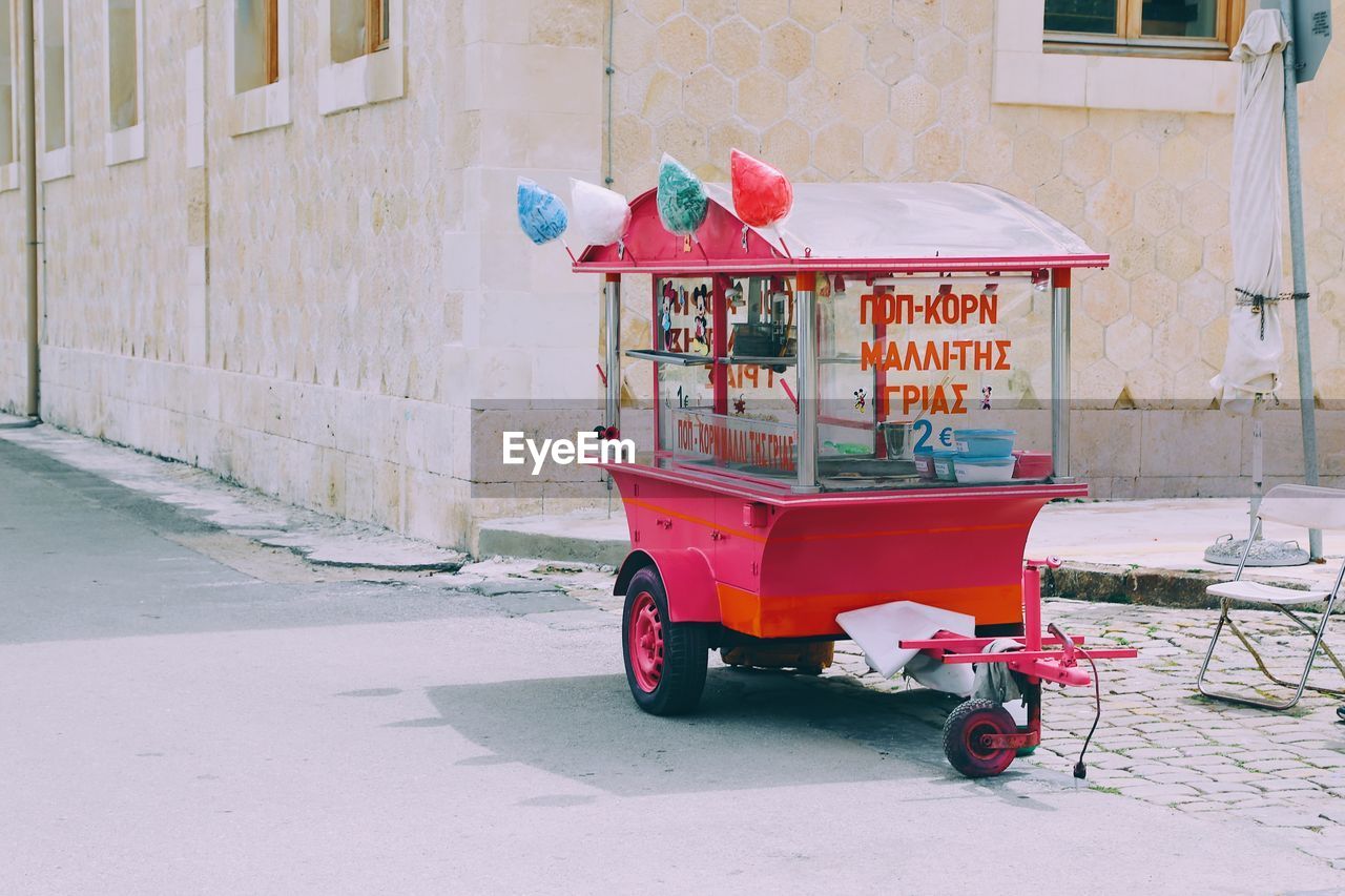 RED BUS ON STREET BY BUILDING