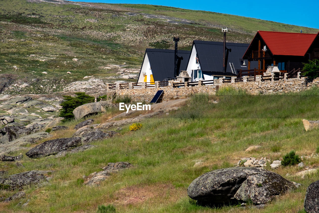 BUILT STRUCTURE ON FIELD AGAINST HOUSES