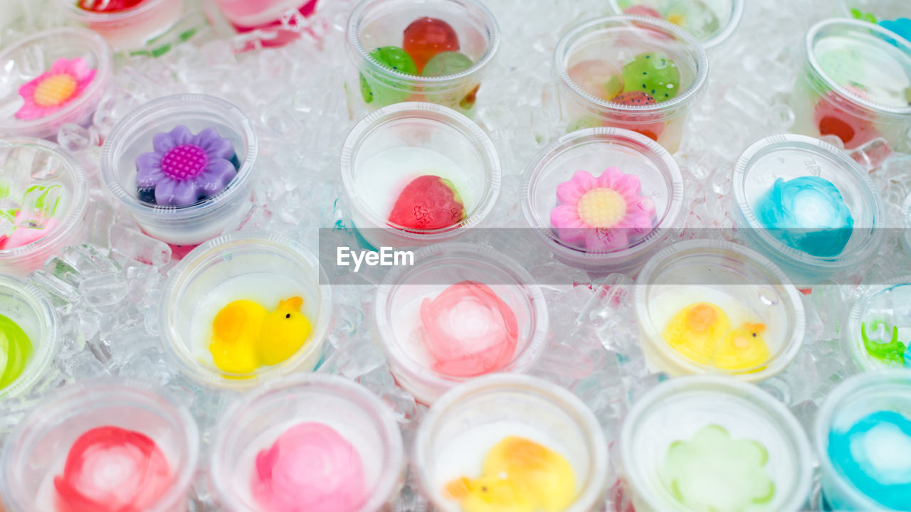 High angle view of decorated drinks amidst ice cubes at table