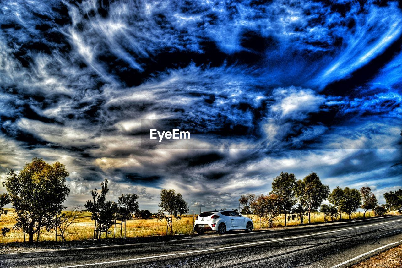 VIEW OF RAILROAD TRACK AGAINST CLOUDY SKY