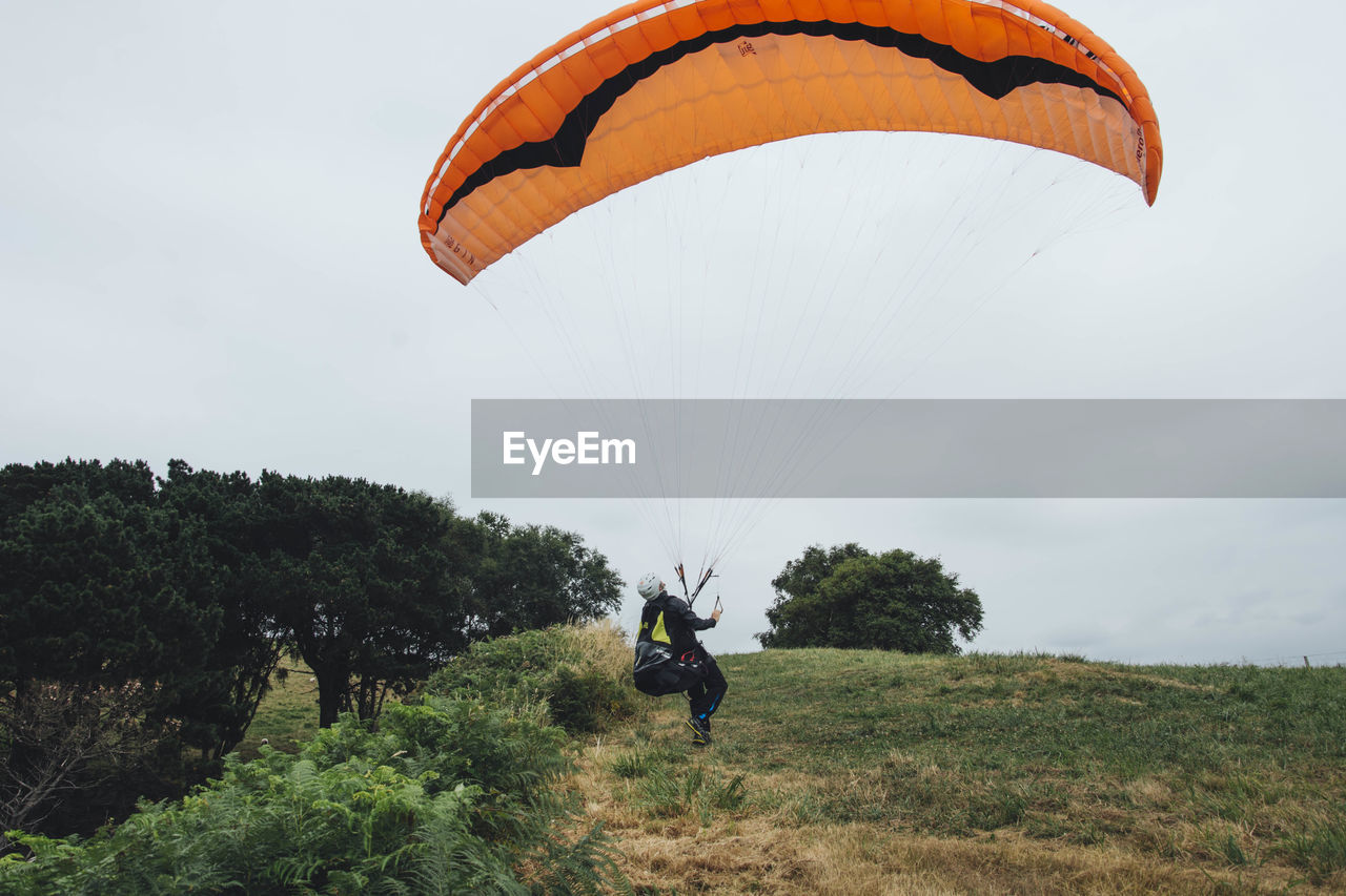 PERSON PARAGLIDING AGAINST SKY