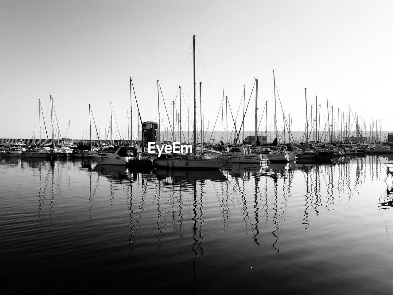 water, nautical vessel, transportation, dock, mode of transportation, sailboat, reflection, marina, sky, pole, harbor, black and white, moored, sea, boat, mast, ship, nature, monochrome, no people, monochrome photography, vehicle, tranquility, watercraft, clear sky, beauty in nature, day, pier, outdoors, tranquil scene, waterfront, travel, copy space, port, travel destinations, scenics - nature