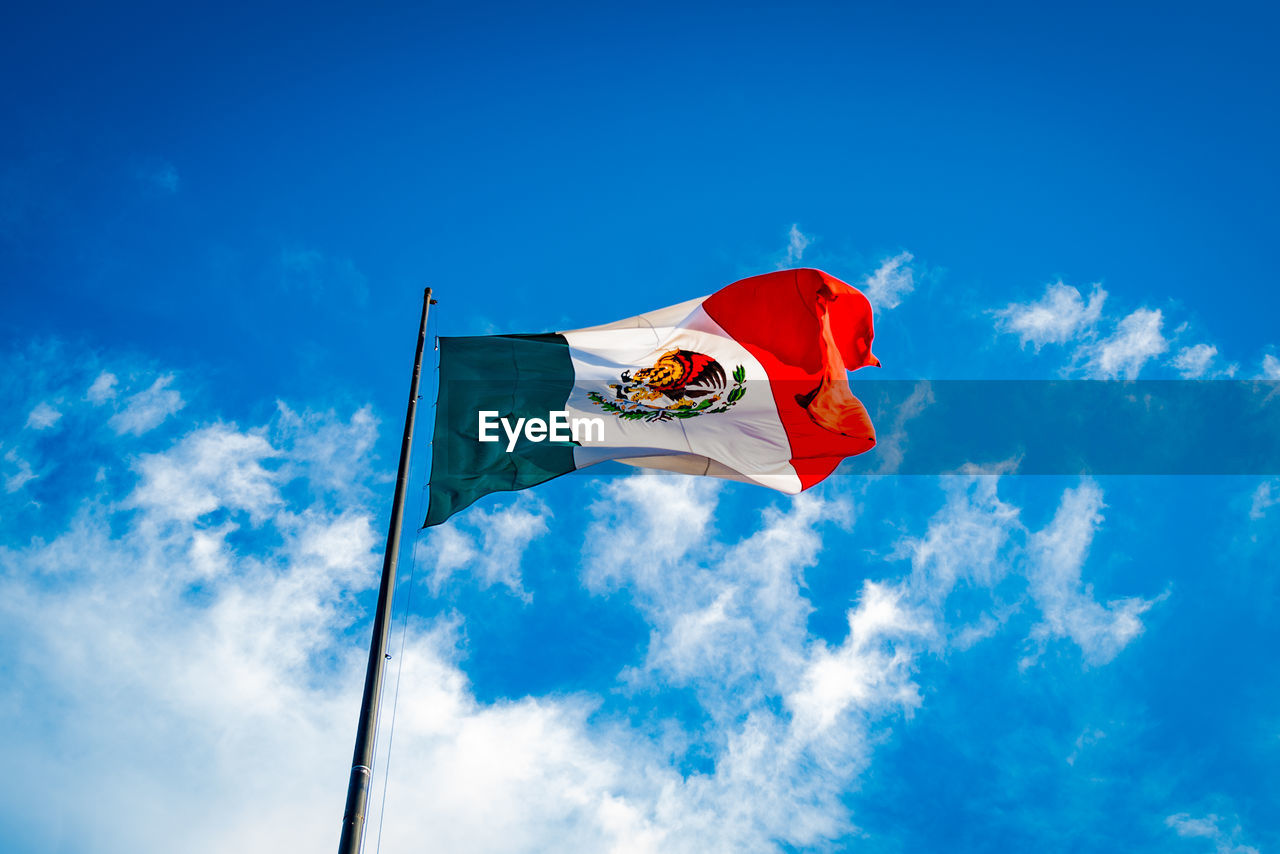 Low angle view of flag against blue sky