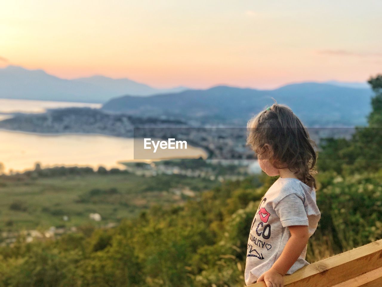 Girl standing by railing on mountain