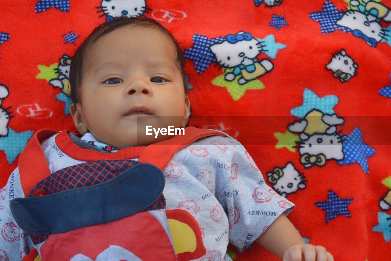 High angle portrait of cute baby lying on bed