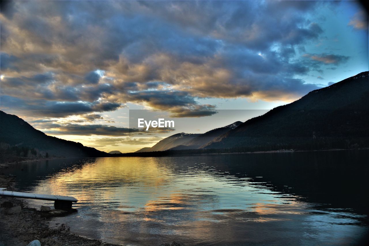 SCENIC VIEW OF LAKE BY SILHOUETTE MOUNTAINS AGAINST SKY