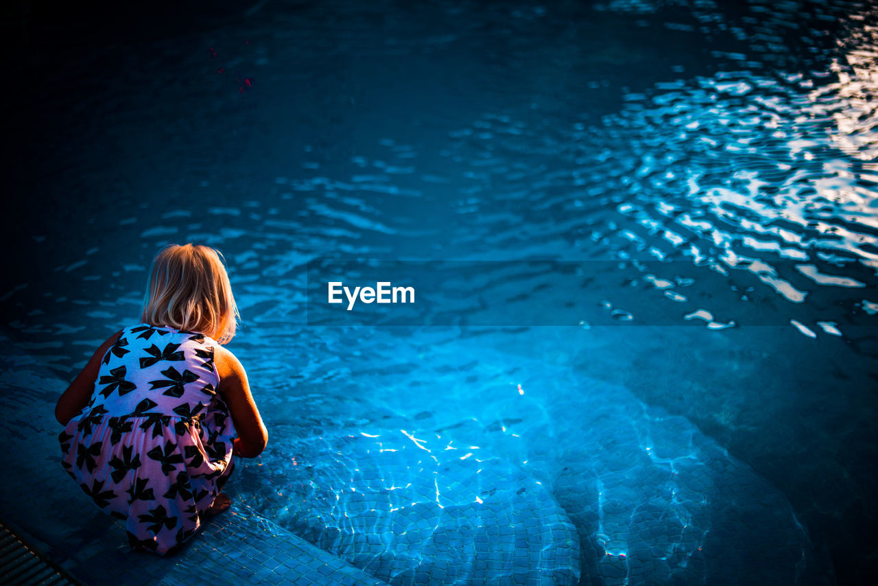 Rear view of child at swimming pool