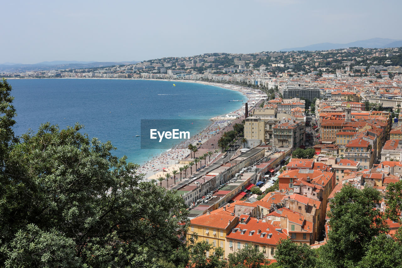 HIGH ANGLE VIEW OF BUILDINGS BY SEA AGAINST SKY