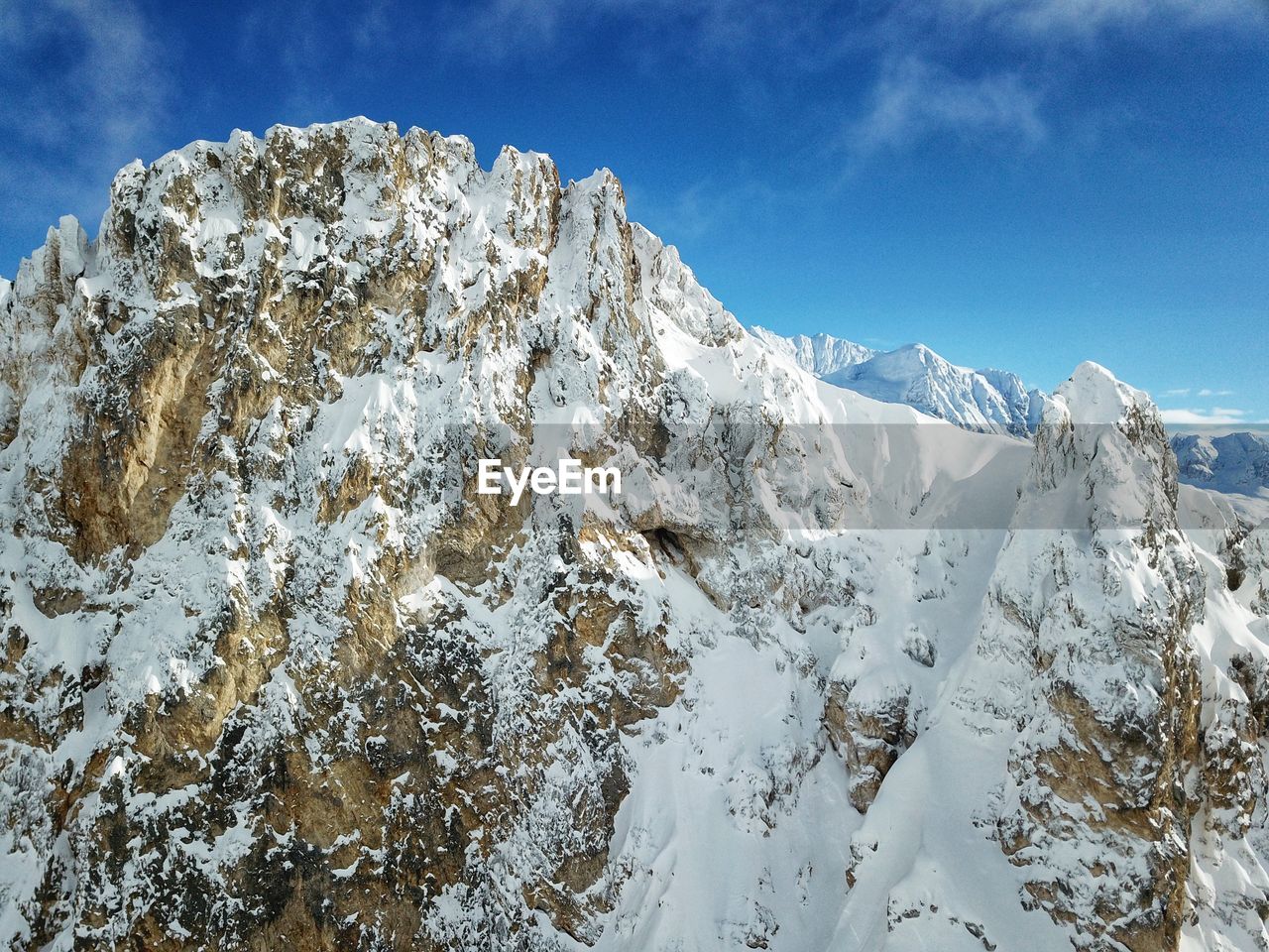 Low angle view of snowcapped mountains against sky