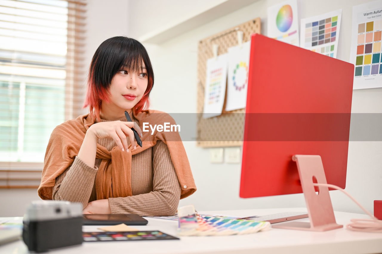 portrait of young woman using laptop while sitting at office