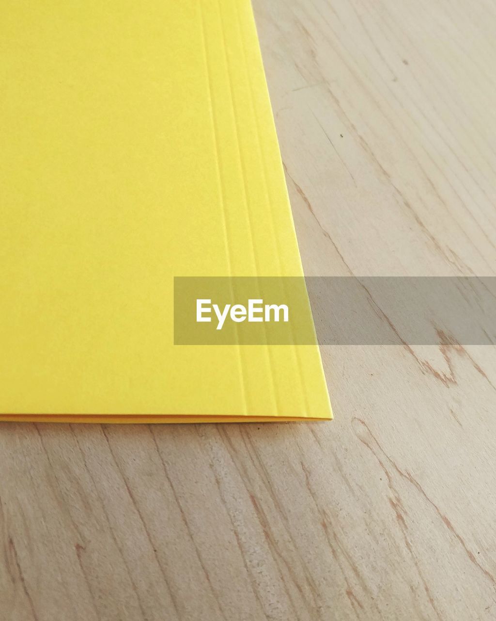 HIGH ANGLE VIEW OF YELLOW TABLE ON HARDWOOD FLOOR AGAINST WALL