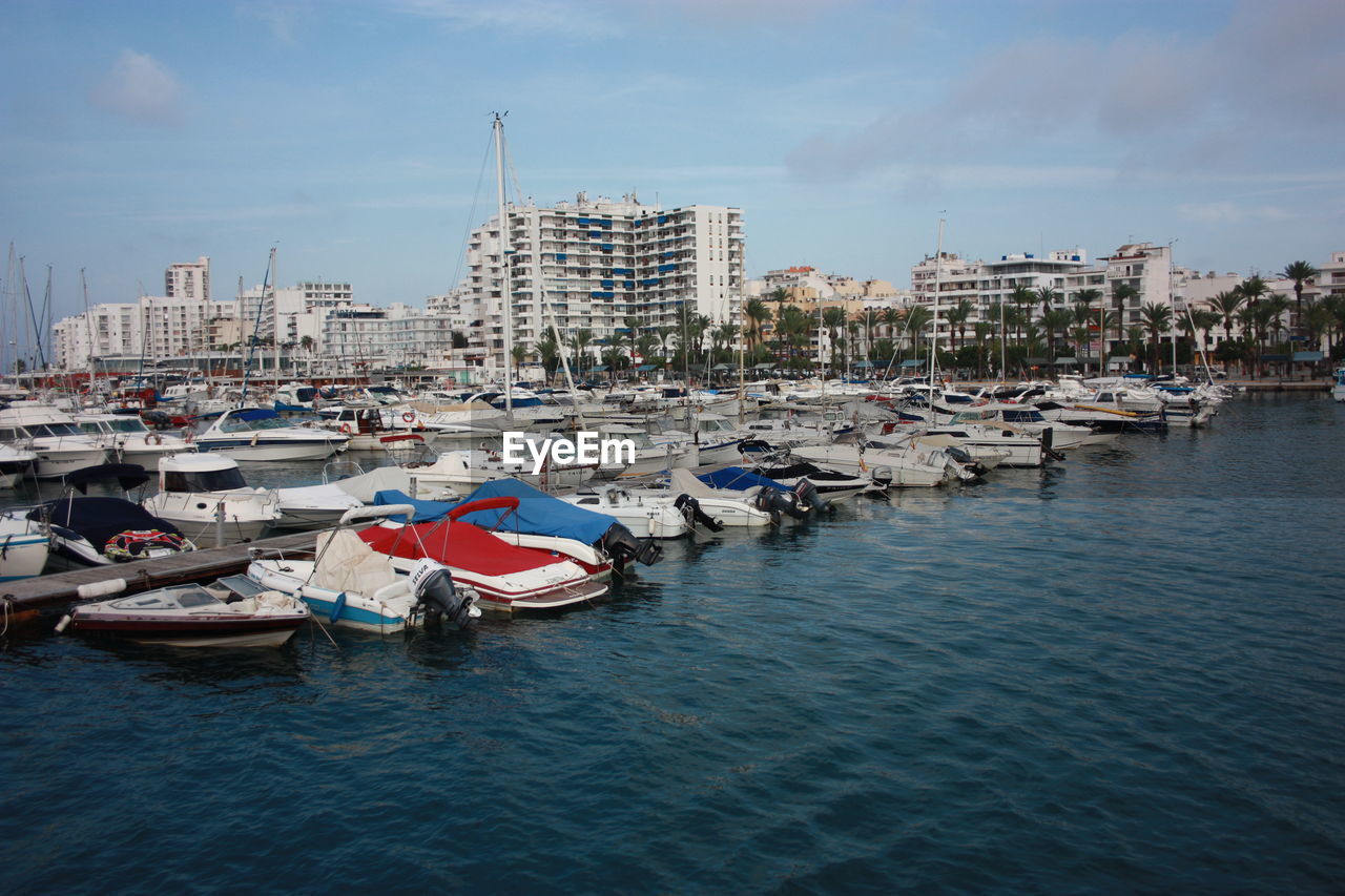 BOATS MOORED IN HARBOR ON CITY