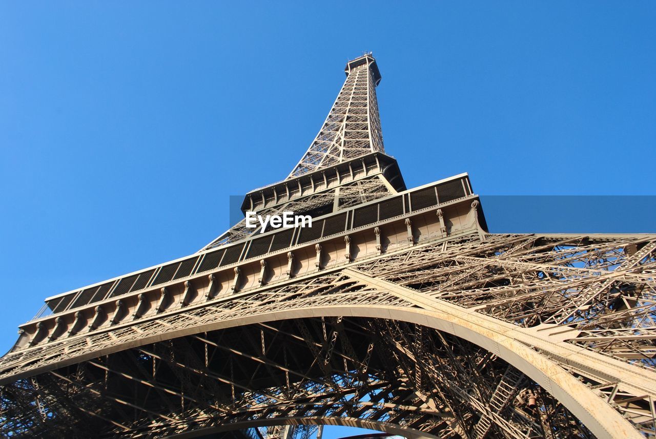 Low angle view of eiffel tower against clear blue sky
