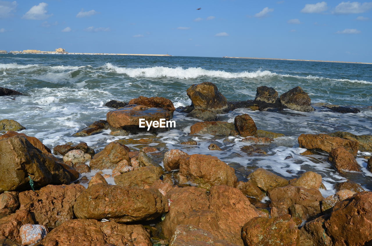 Rocks on beach against sky