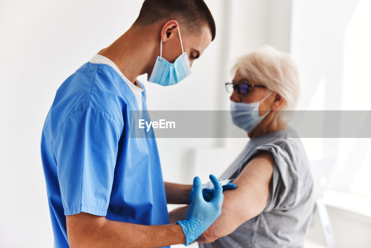 Side view of female doctor examining patient at clinic