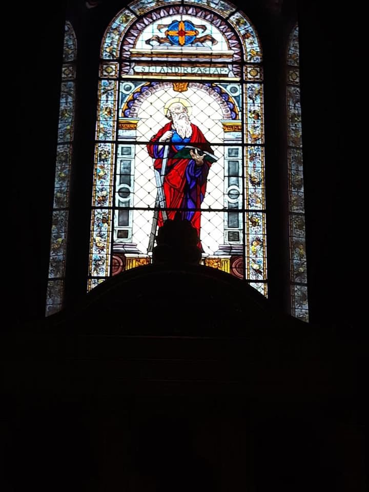 religion, belief, architecture, stained glass, window, spirituality, place of worship, built structure, glass, building, indoors, human representation, representation, creativity, no people, male likeness, catholicism, multi colored, low angle view, arch, darkness