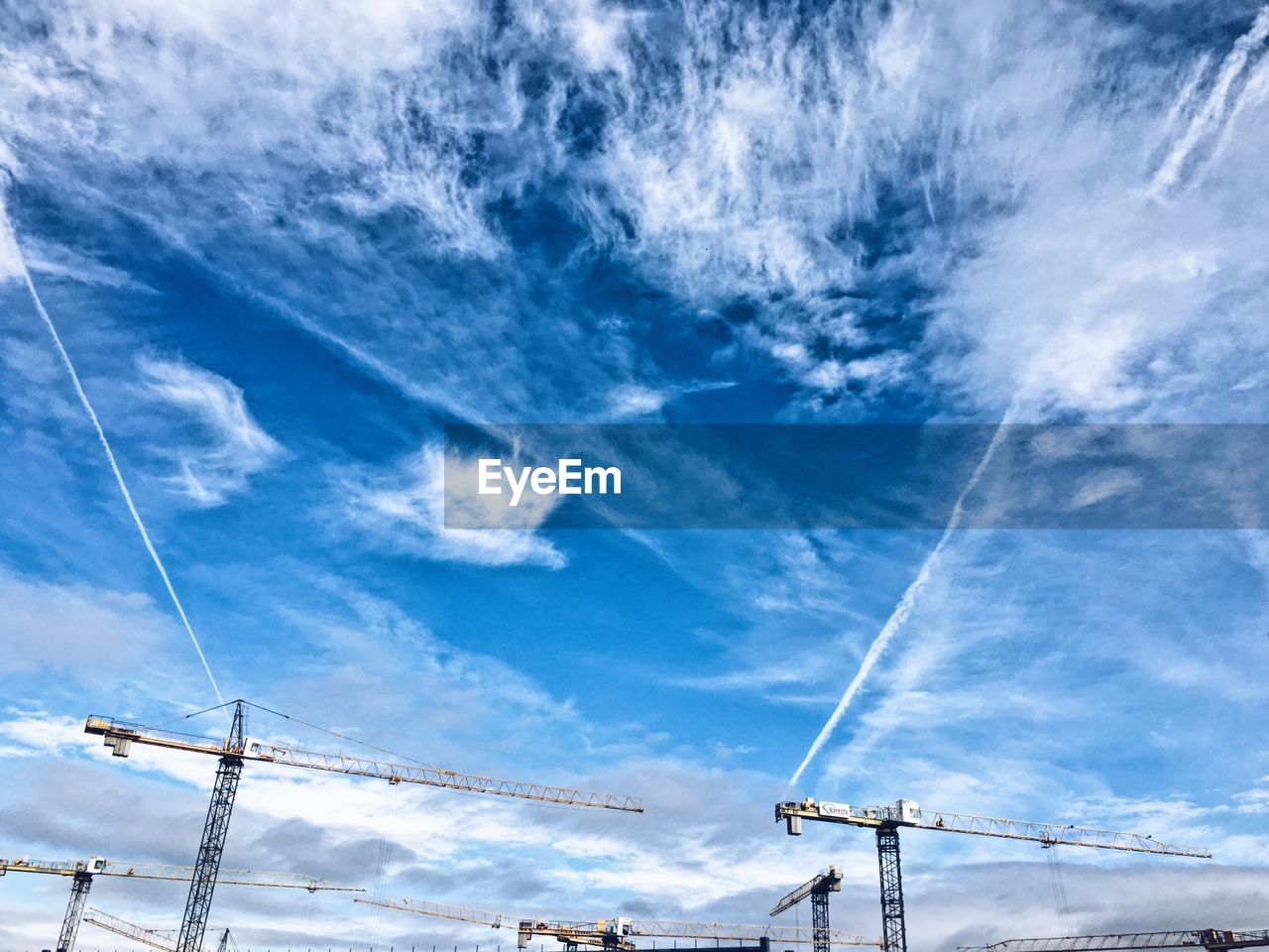 LOW ANGLE VIEW OF VAPOR TRAILS AGAINST BLUE SKY