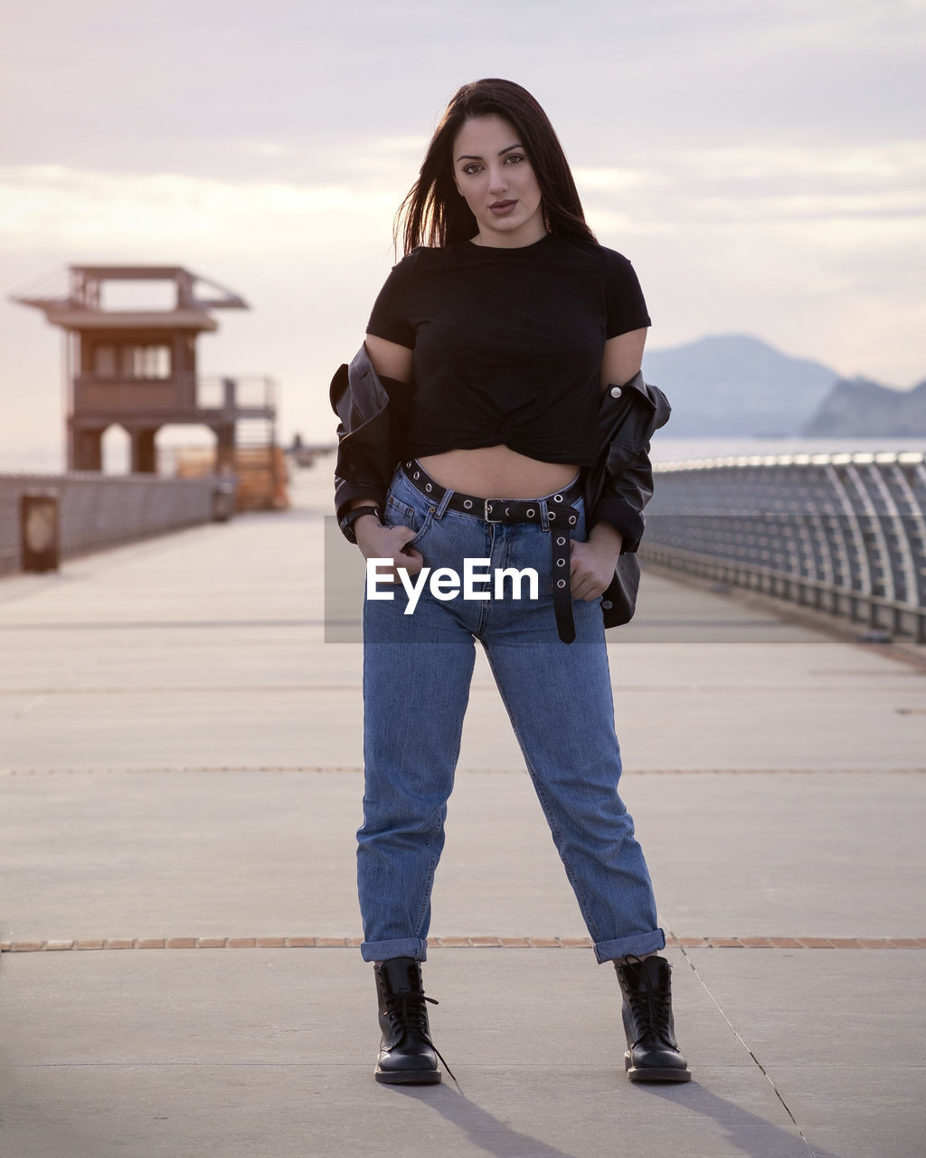 Portrait of young woman standing against wall